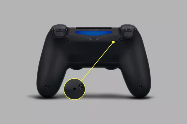A DualShock 4 controller with the reset hole highlighted